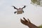 Assembled Drone quadcopter delivering a package and hands receiving the parcel