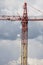 Assembling of crane on dramatic cloudy background. Dangerous height situation.