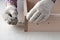 Assembling  furniture box, gloved hands tighten  screw with  key