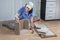 Assembling of furniture, woman mounts box of chipboard, using glue.