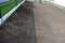 Assembly of garden curbs made of black plastic. The curb separates lawns and flowerbeds so that there is a clear interface and the