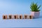 assets - word from wooden blocks with letters, useful or valuable thing assets concept, random letters around blue