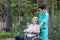 Assistance and care from a doctor Asian senior or elderly old lady woman patient in a nursing hospital ward, seated in a