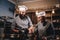 Assistant cook grinds sesame seeds in a mortar for cooking bread. Chef teaching his assistant to bake the bread in the