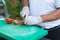 Assistant cook slices tomatoes on the board