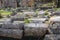 Assorted ancient archeological pillars lined up on the ground at Corinth Greece - selective focus