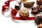 Assorted bonbons with red ribbon on a white table close-up