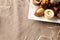 Assorted bonbons in a white dish with straw decoration top