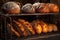 assorted bread loaves cooling on a rack by stone oven