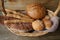 Assorted bread and sesame breadsticks in a basket on a wooden rustic table