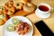 Assorted breads, kiwi fruit and hot tea for breakfast with mobile phone