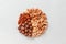 Assorted brown nuts circle on a gray background. Macadamia, cashews, minced almonds, pecans, wholesome food