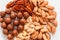 Assorted brown nuts on a gray background. Macadami, cashews, chopped almonds, pecans healthy food