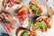 Assorted bruschetta with various toppings. Appetizing bruschetta or crudo crostini. Variety of small sandwiches. Mix bruschetta on