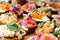 Assorted bruschettas on a wooden tray. Fish, meat, vegetables and herbs. Appetizing snacks. Close-up