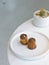 Assorted canneles on white round plate on white marble table with blur cactus plant