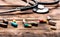 Assorted capsules pharmaceutical drugs and stethoscope wooden background, medical care