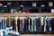 Assorted casual clothes on shelves and hangers