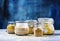 Assorted cereals in glass jars: kinoa, bulgur, couscous, orzo, b