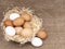Assorted chicken, hens eggs in basket with straw on hessian rustic background with copy space. Different colors: brown