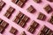 Assorted chocolate candies on pink background, top view. Chocolate pralines flat lay. Handmade chocolate candy sweets