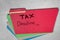 Assorted color file folders fanned out filing office materials and supplies tax deadline handwritten on red file