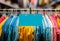 Assorted colorful shirts on hangers against a blurry background with a blank sale tag.