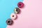Assorted coloured donuts in a row, minimalism on a blue and pink background, top view
