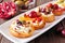 Assorted crostini appetizers with a variety of toppings, close up on a serving plate