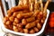 Assorted deep fried street food sold at a food cart along a sidewalk