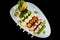 Assorted delicious mixed grilled with vegetable on white plate on black background