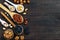 Assorted different nuts, prunes, pumpkin seeds in spoons on a dark wooden background.