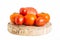 Assorted different varieties of pink, yellow and orange tomatoes on a wooden stand. White background, isolate. Autumn