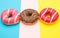 Assorted donuts with chocolate on colored background