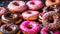 assorted donuts with chocolate frosted, pink glazed and sprinkles donuts.