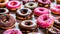 assorted donuts with chocolate frosted, pink glazed and sprinkles donuts.