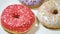 Assorted donuts with colorful sprinkles on white plate