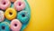 Assorted donuts with colorful sprinkles on a yellow background.