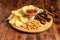 Assorted dry snacks on a wooden board. Chips, peanuts, croutons, wasabi