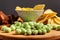 Assorted dry snacks on a wooden board. Chips, peanuts, croutons, wasabi