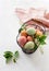 Assorted Easter eggs in basket with spring flowers and linen napkin