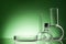 Assorted empty laboratory glassware, test-tubes. Green tone medical background. Copy space