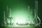 Assorted empty laboratory glassware, test-tubes. Green tone medical background. Copy space