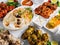 Assorted famous indian and pakistani food table vegetable biryani, Butter Chicken, paneer Chicken Tikka boti kebab, lime, Kali