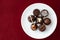 Assorted fancy chocolate candy on a white plate on a red background