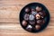 Assorted fancy milk and dark chocolate candy on a rustic black plate on a wood background