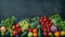 Assorted fresh fruits and vegetables on dark surface