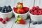 Assorted fresh juicy berries in three tiny bowls