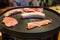 Assorted fresh meat on a round portable grill