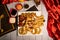 Assorted fried snacks platter with fried onion rings, shrimps, crackers, bq chicken wings, soy mayo dip sauce and black pepper